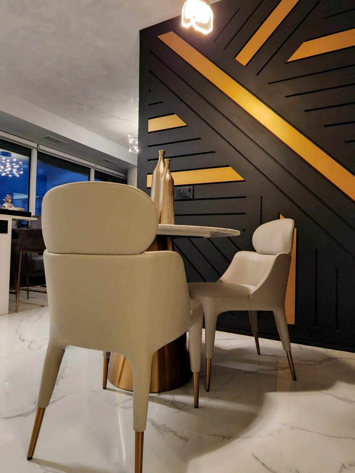 Dining nook with a black and gold geometric feature wall