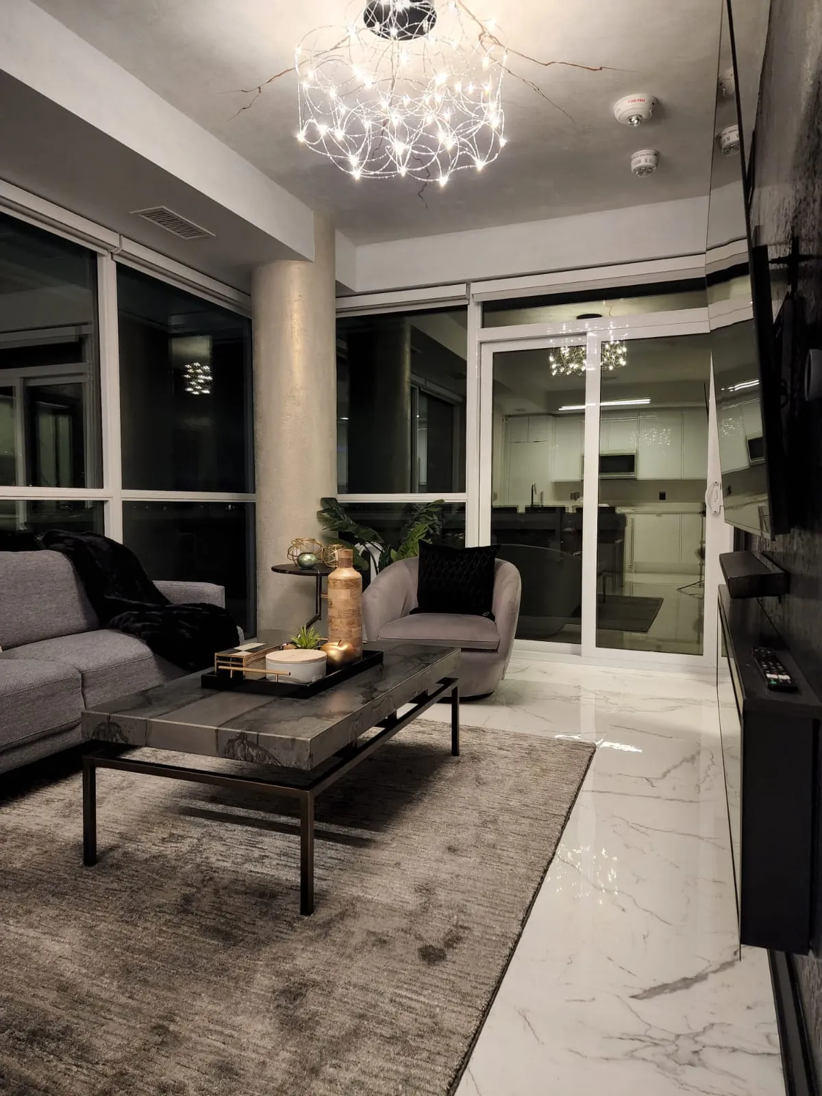 Living room with a chandelier and floor-to-ceiling windows